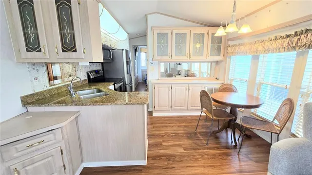 a kitchen with granite countertop a refrigerator stove and microwave