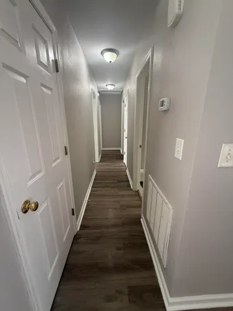 a view of a hallway with wooden floor
