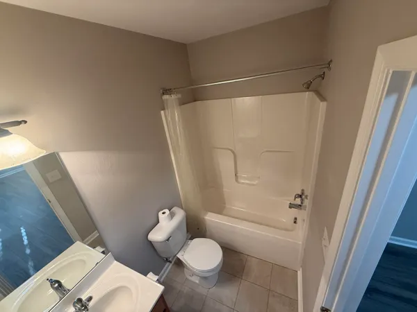 a bathroom with a granite countertop shower and a toilet
