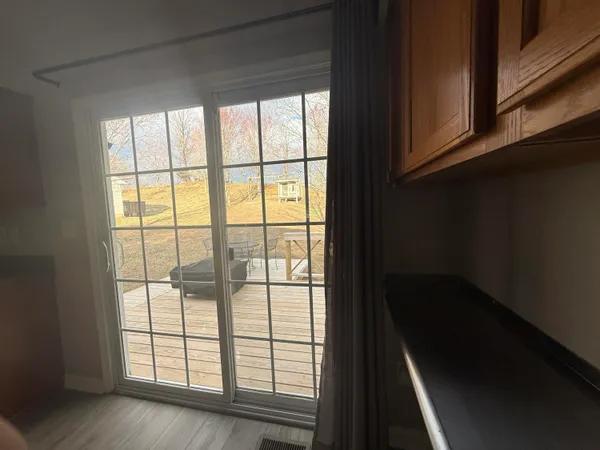 a view of empty room with wooden floor and windows
