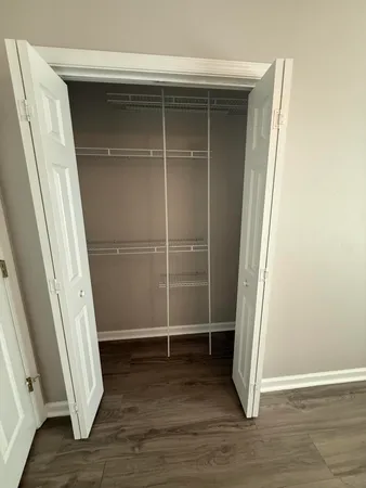 an empty room with wooden floor and white walls