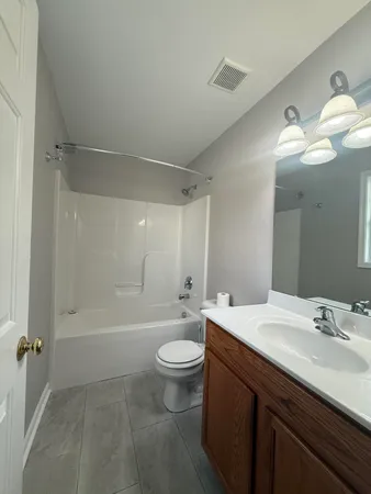 a bathroom with a sink a toilet and a large mirror