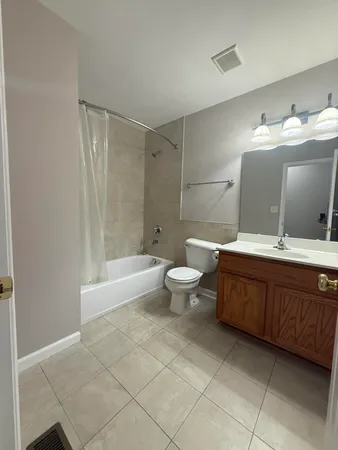 a spacious bathroom with a bathtub shower sink mirror and toilet