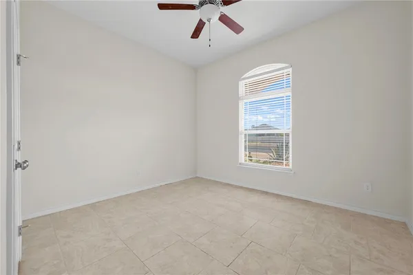 an empty room with a ceiling fan and window