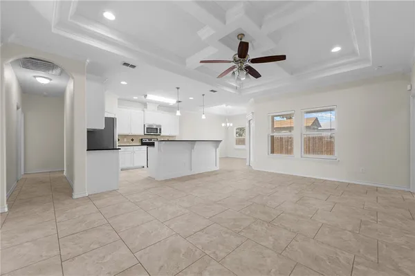 a view of an empty room and kitchen view