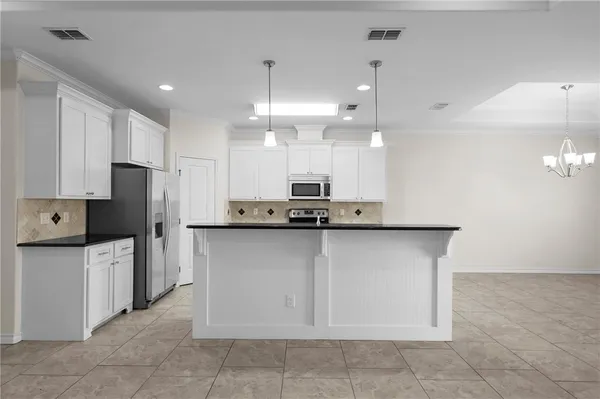 a kitchen with stainless steel appliances granite countertop a refrigerator a sink and a oven