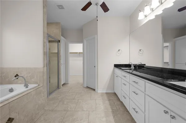 a spacious bathroom with a granite countertop sink a mirror and shower