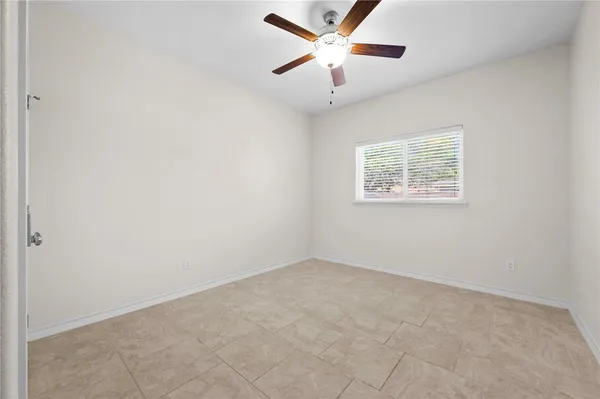 an empty room with a window and a fan