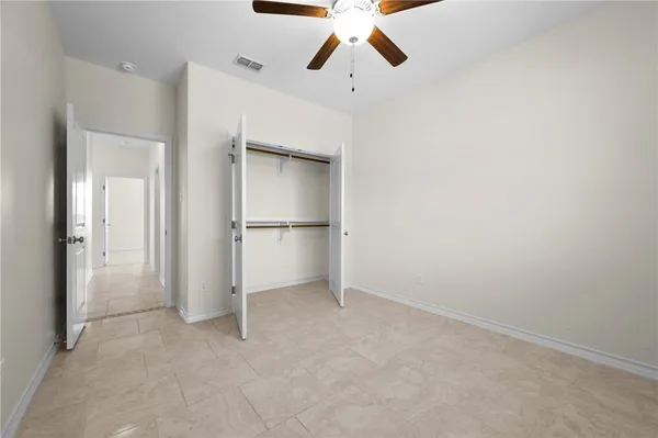 an empty room with closet and windows