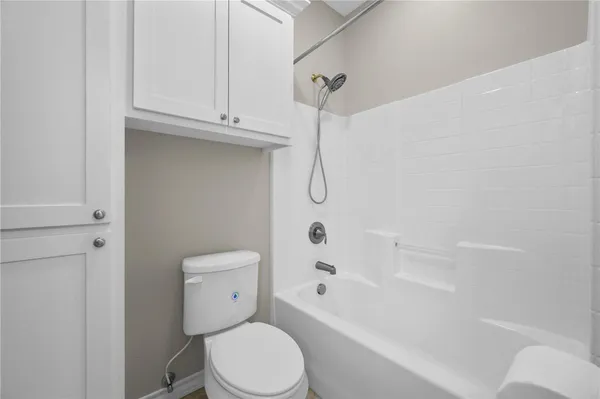 a white toilet sitting next to a bath tub