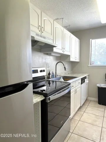 a kitchen with stainless steel appliances granite countertop a sink and a stove