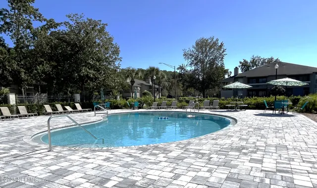 a view of swimming pool with table and chairs a fire pit