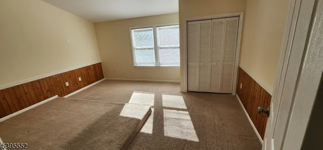 a view of a room with wooden floor and a ceiling fan