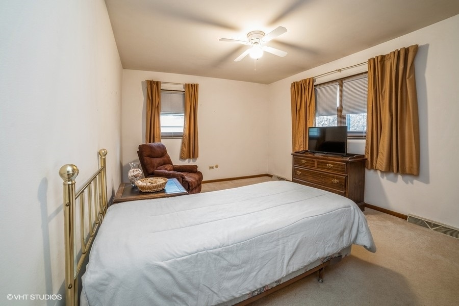 1208 Ridgeway Drive Elgin, IL 60123 - Photo 7 of 10 a bedroom with a bed and a flat screen tv