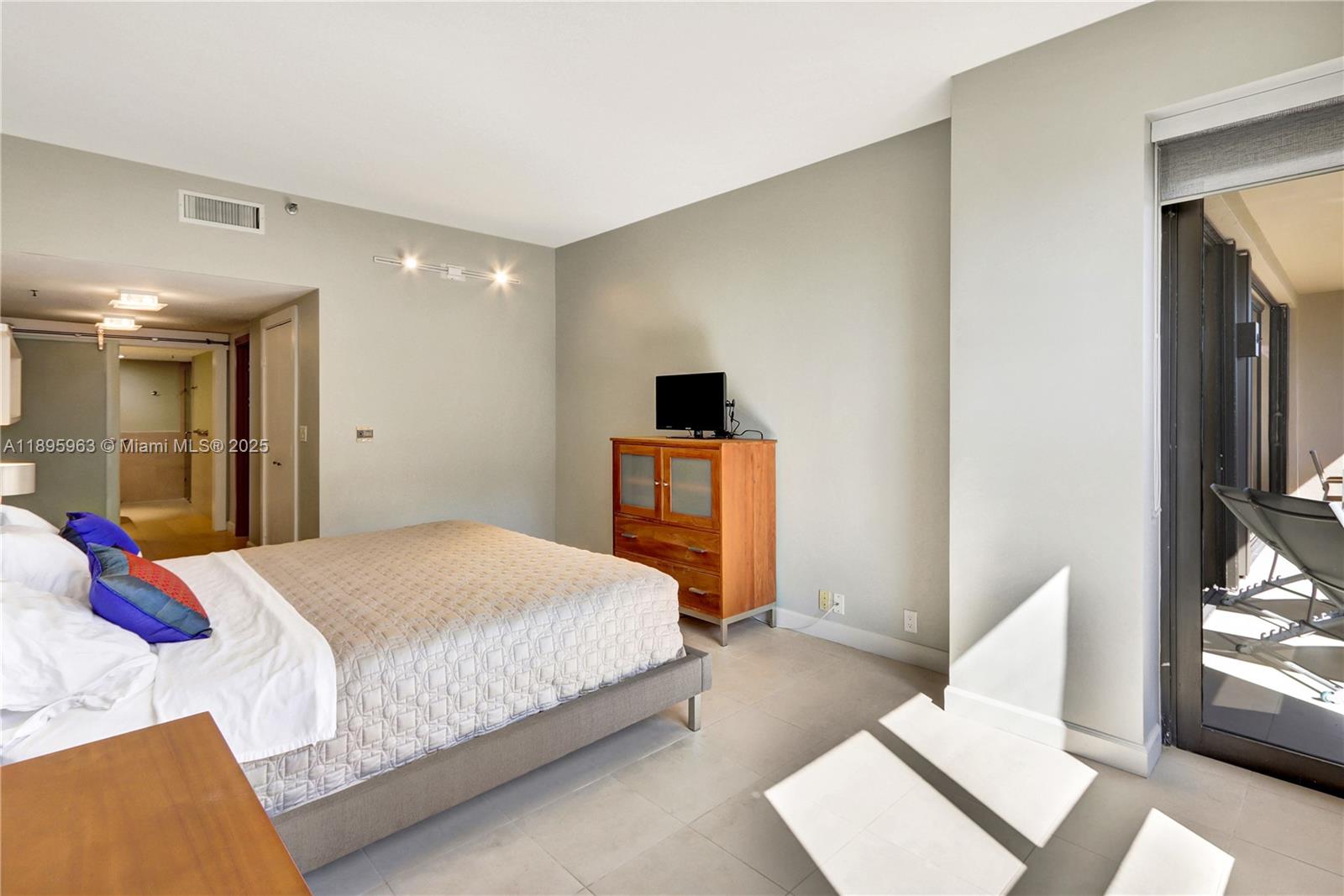 251 Crandon Boulevard, Unit 628 Key Biscayne, FL 33149 - Photo 19 of 32 a bedroom with a bed and a television