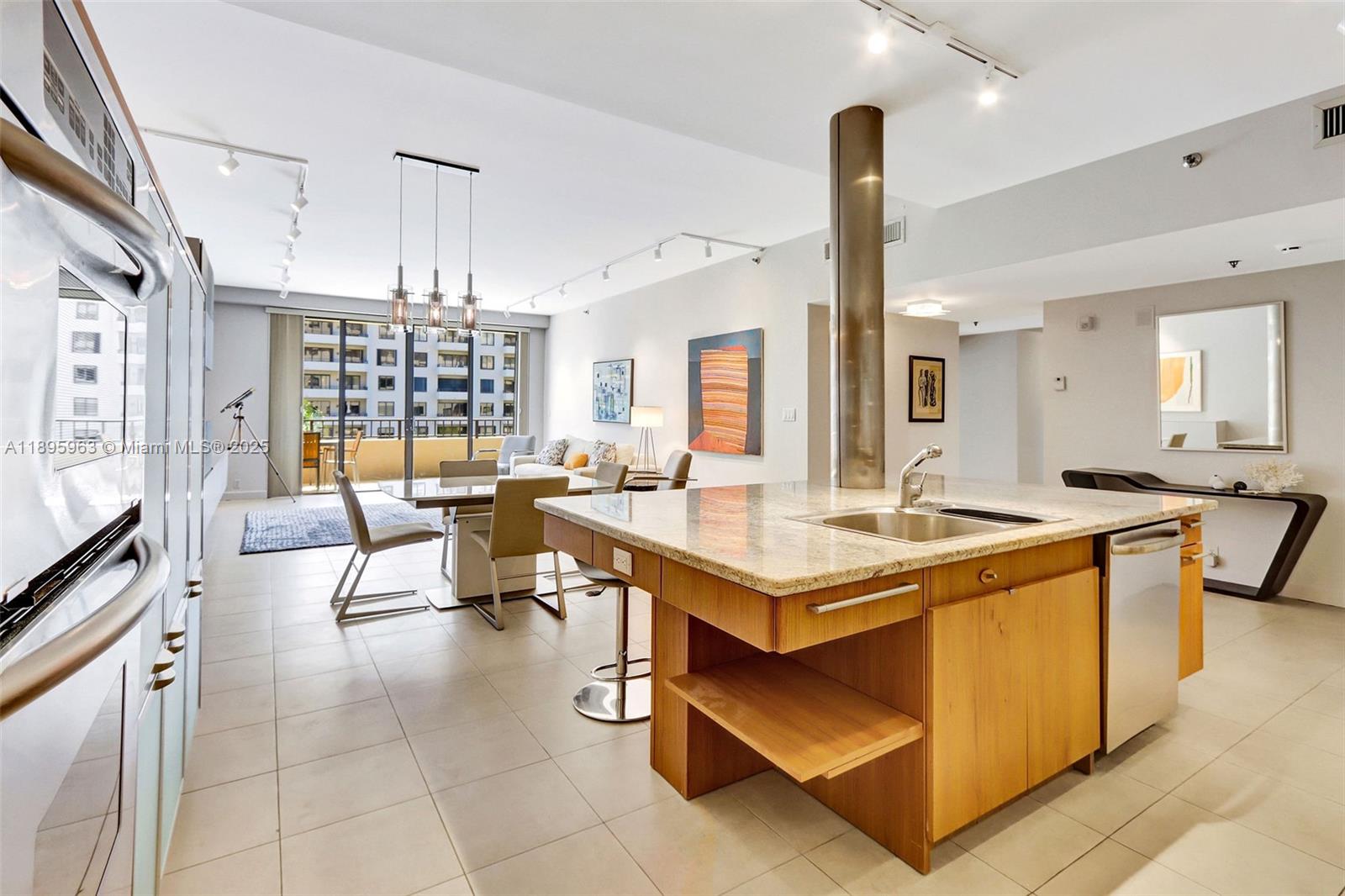 251 Crandon Boulevard, Unit 628 Key Biscayne, FL 33149 - Photo 10 of 32 a open kitchen with stainless steel appliances kitchen island granite countertop a table and chairs in it