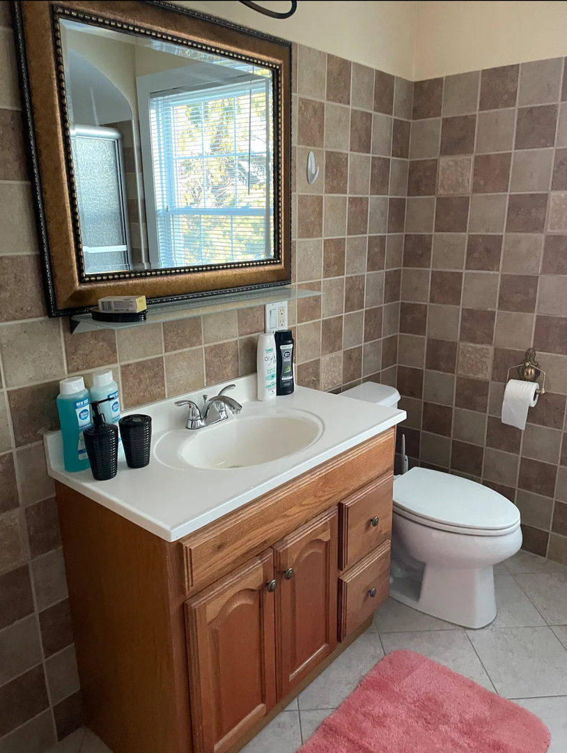 6101 West Fletcher Street, Unit 1 Chicago, IL 60634 - Photo 12 of 17 a bathroom with a sink a toilet and mirror