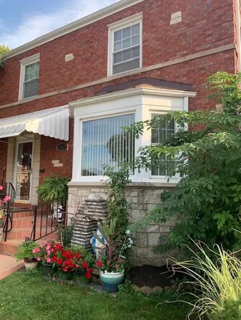 a front view of a house with a yard and potted plants