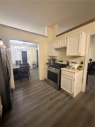 a kitchen with refrigerator a microwave a sink and cabinets