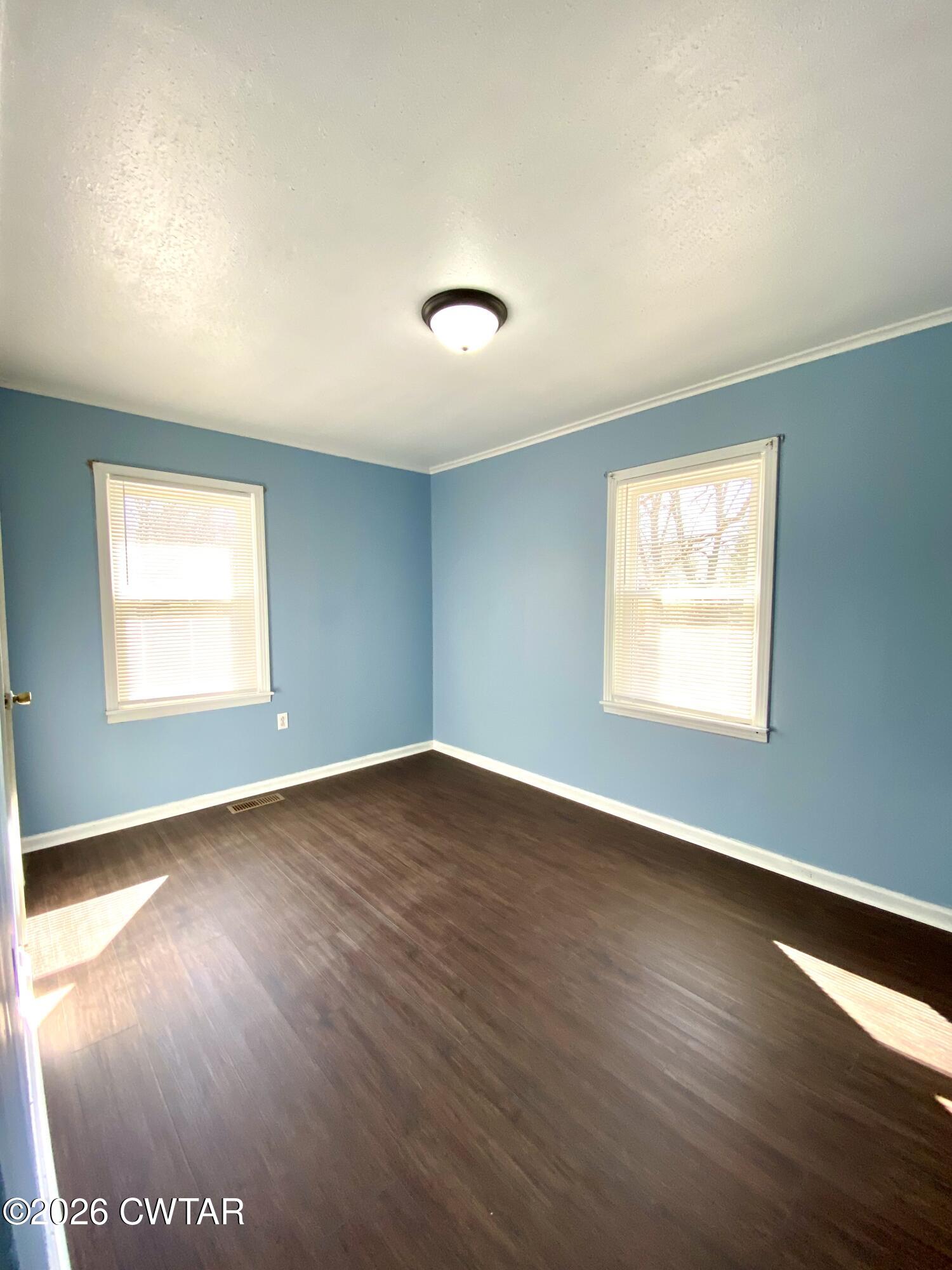 20 South Garland Street McKenzie, TN 38201 - Photo 11 of 18 an empty room with wooden floor and windows