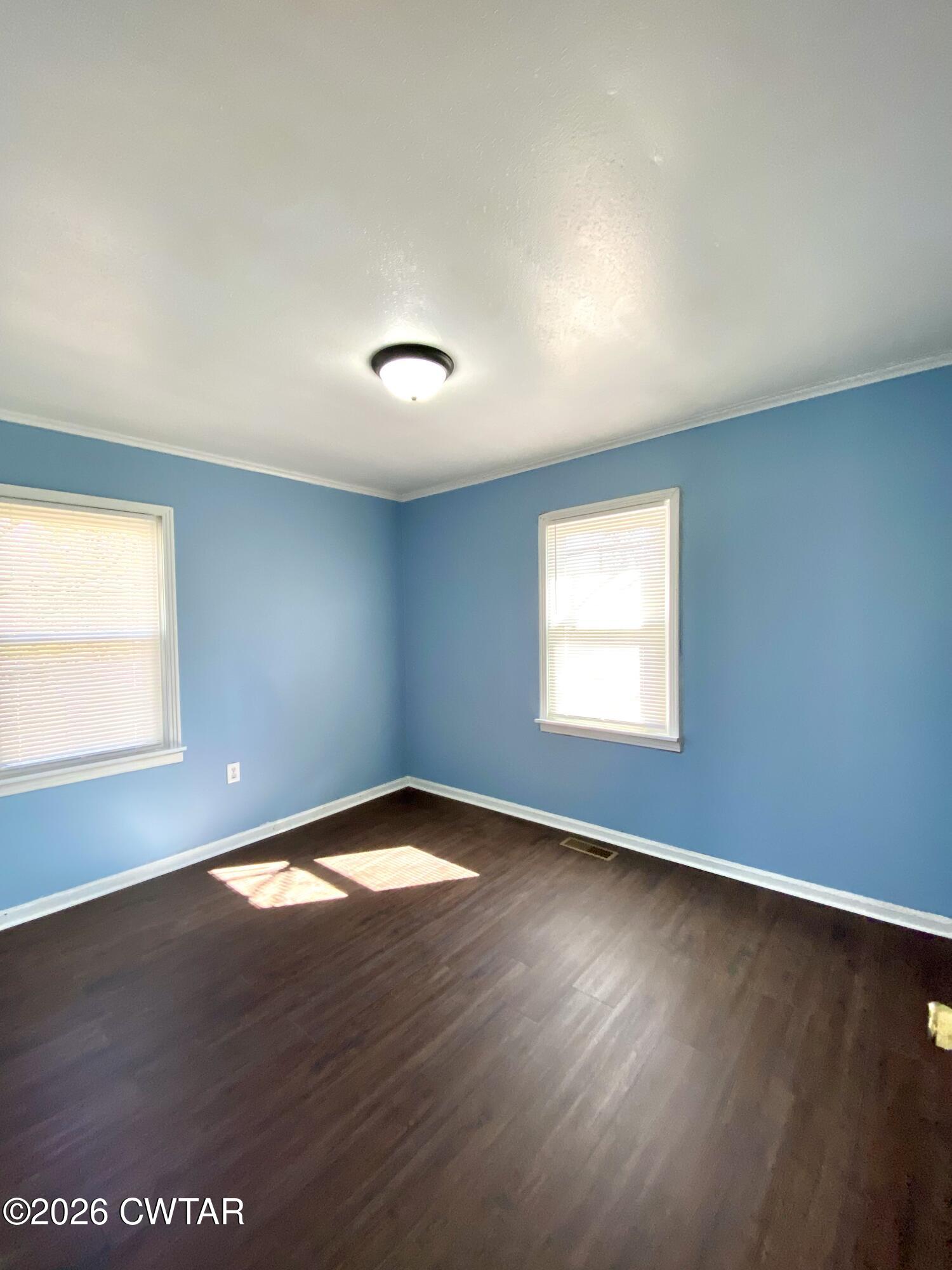 20 South Garland Street McKenzie, TN 38201 - Photo 12 of 18 an empty room with wooden floor and windows