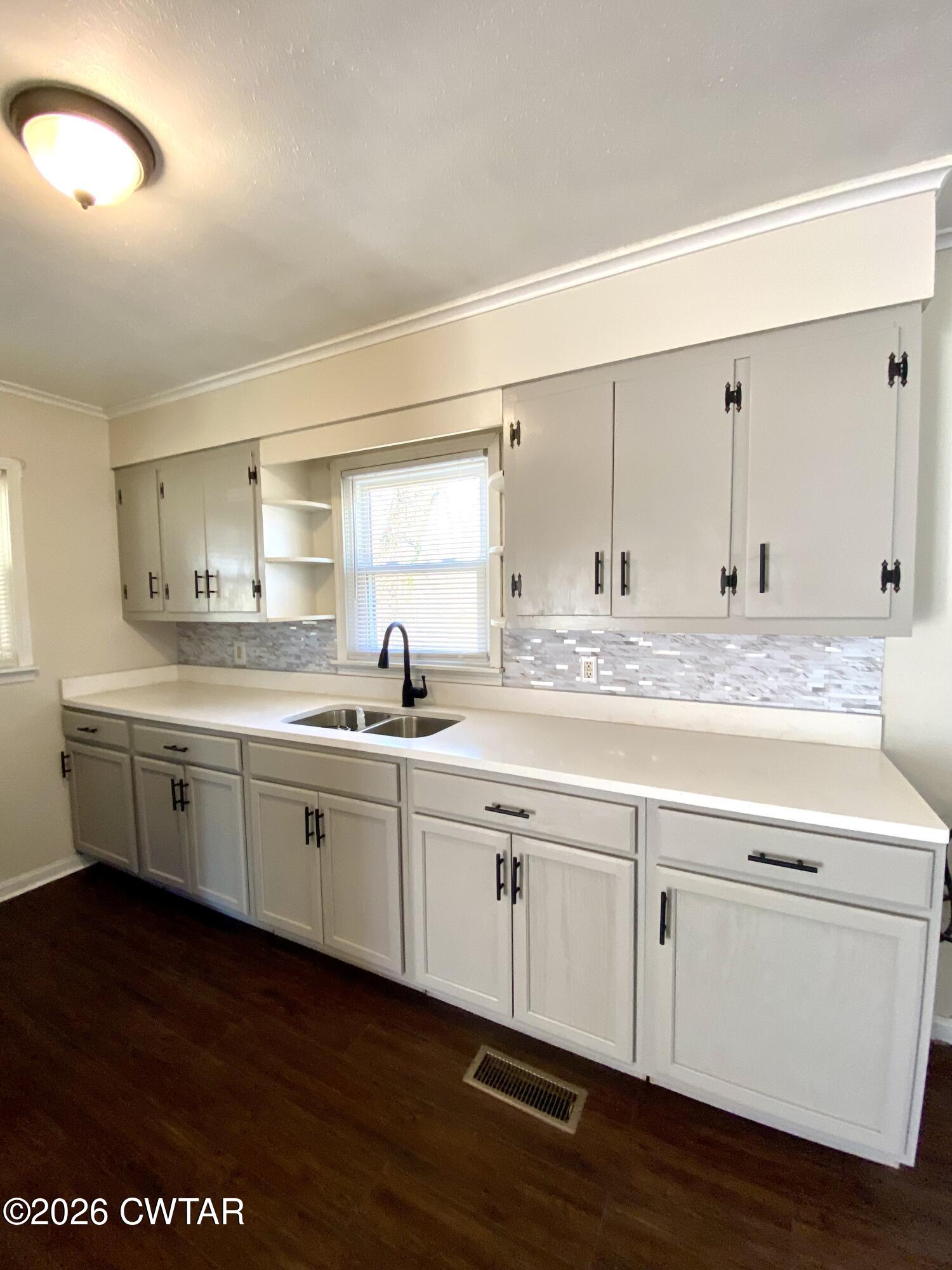 20 South Garland Street McKenzie, TN 38201 - Photo 4 of 18 a kitchen with stainless steel appliances granite countertop a sink and cabinets with wooden floor
