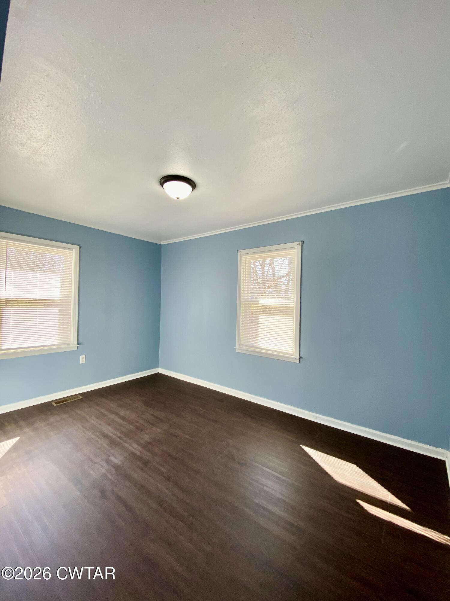 20 South Garland Street McKenzie, TN 38201 - Photo 10 of 18 an empty room with wooden floor and windows