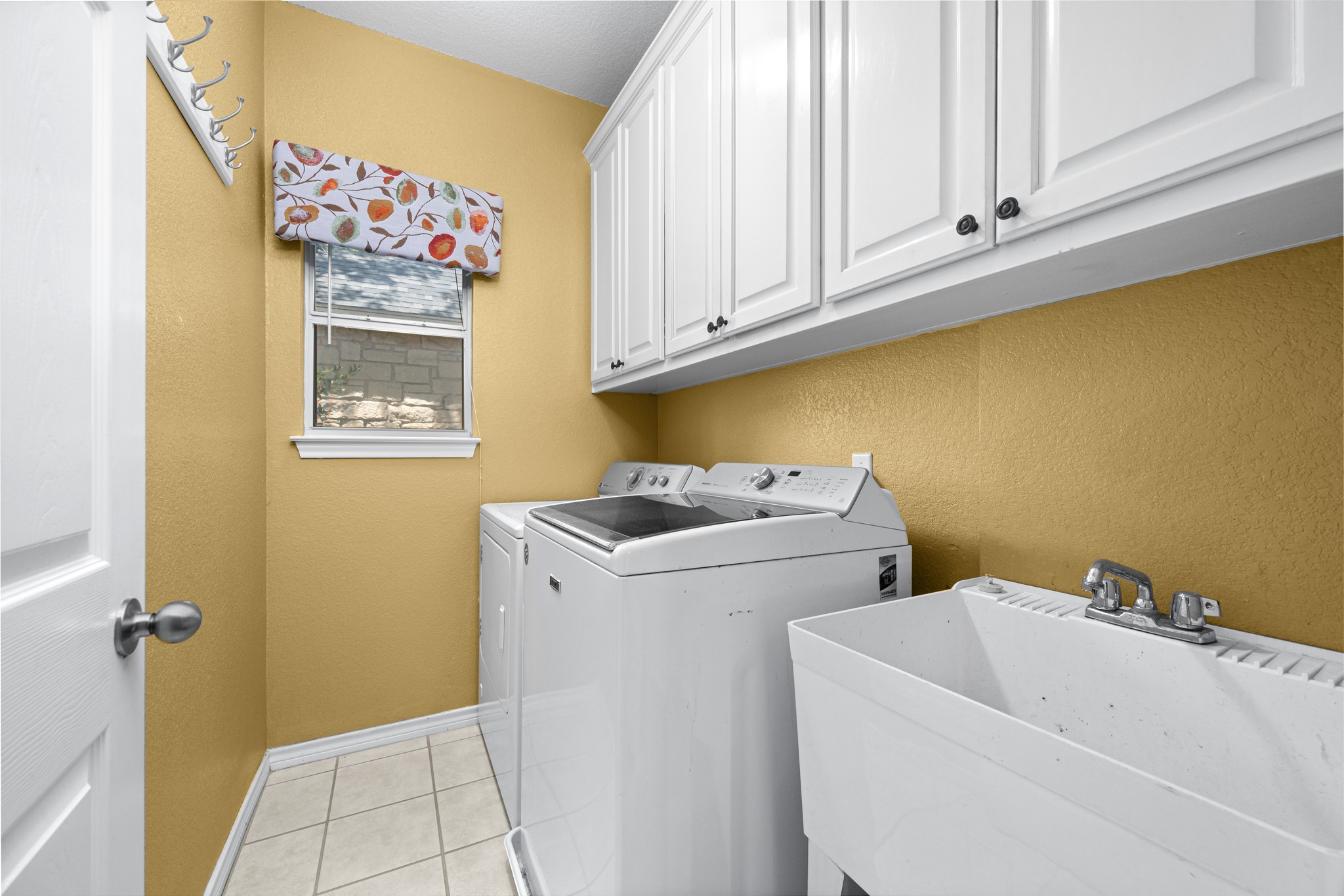 108 Thornwood Road Georgetown, TX 78628 - Photo 24 of 40 Functional laundry room featuring a utility sink, a window, and ample cabinet storage.