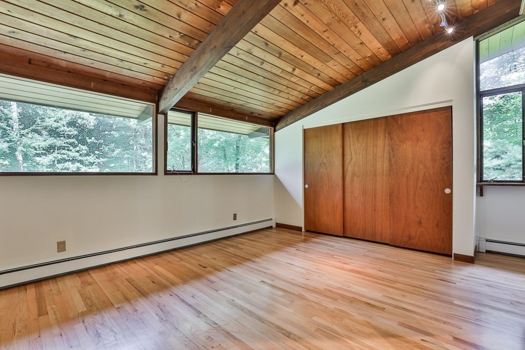 62 Woodside Road Harvard, MA 01451 - Photo 20 of 36 an empty room with wooden floor and windows