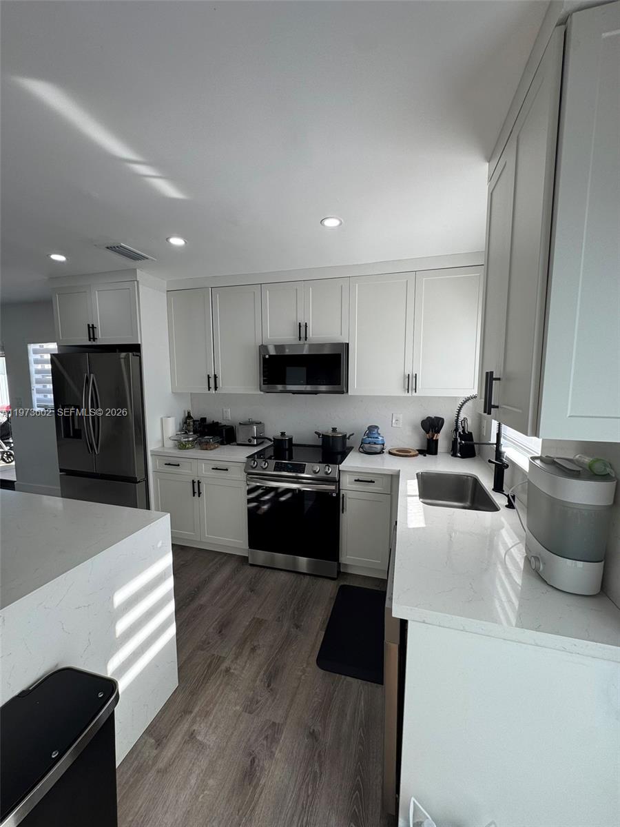 12534 Southwest 27th Street Miami, FL 33175 - Photo 14 of 49 a kitchen with stainless steel appliances a stove a sink a refrigerator white cabinets and a oven
