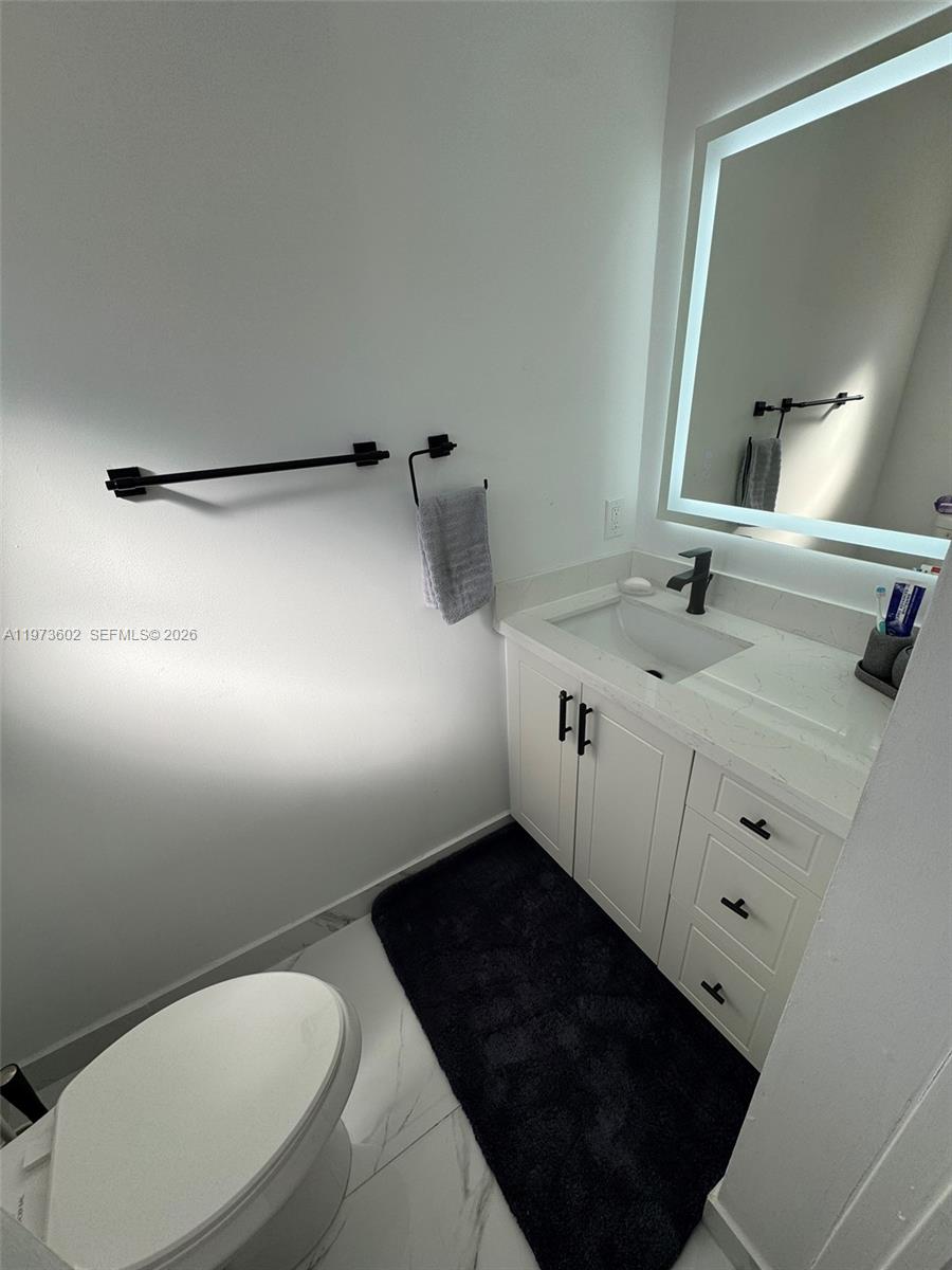 12534 Southwest 27th Street Miami, FL 33175 - Photo 18 of 49 a bathroom with a toilet sink and mirror