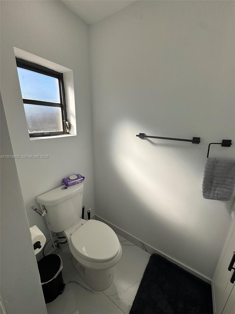 12534 Southwest 27th Street Miami, FL 33175 - Photo 19 of 49 a white toilet sitting next to a bathroom sink