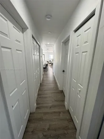 a view of a hallway with wooden floor and stairs