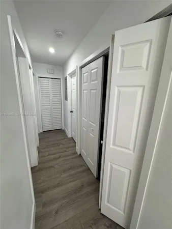 a view of a hallway with wooden floor