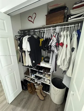 a view of walk in closet with clothes and shoes