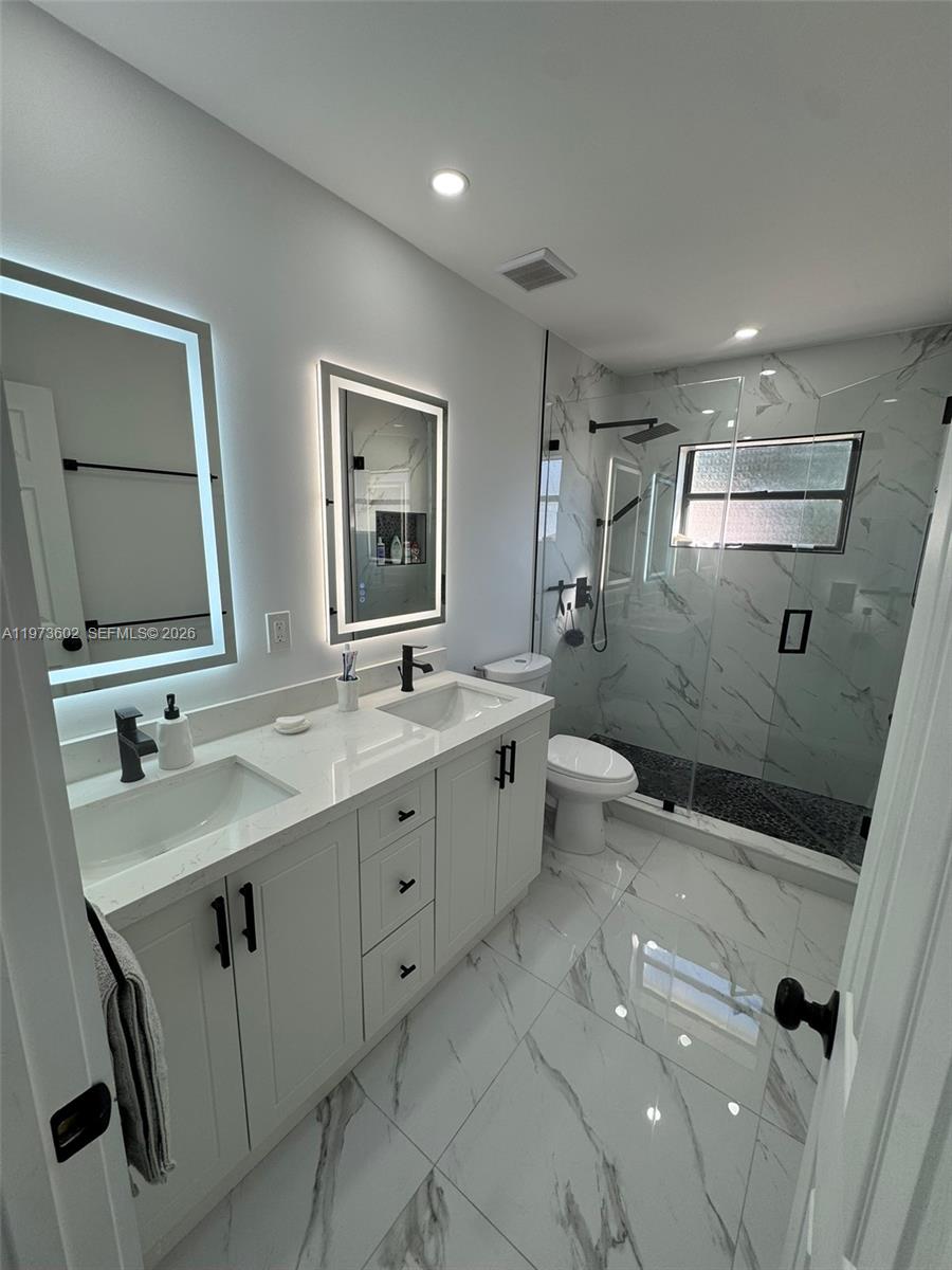 12534 Southwest 27th Street Miami, FL 33175 - Photo 29 of 49 a bathroom with a double vanity sink mirror and toilet