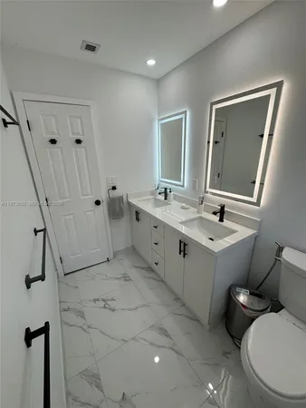 a bathroom with a toilet sink and mirror