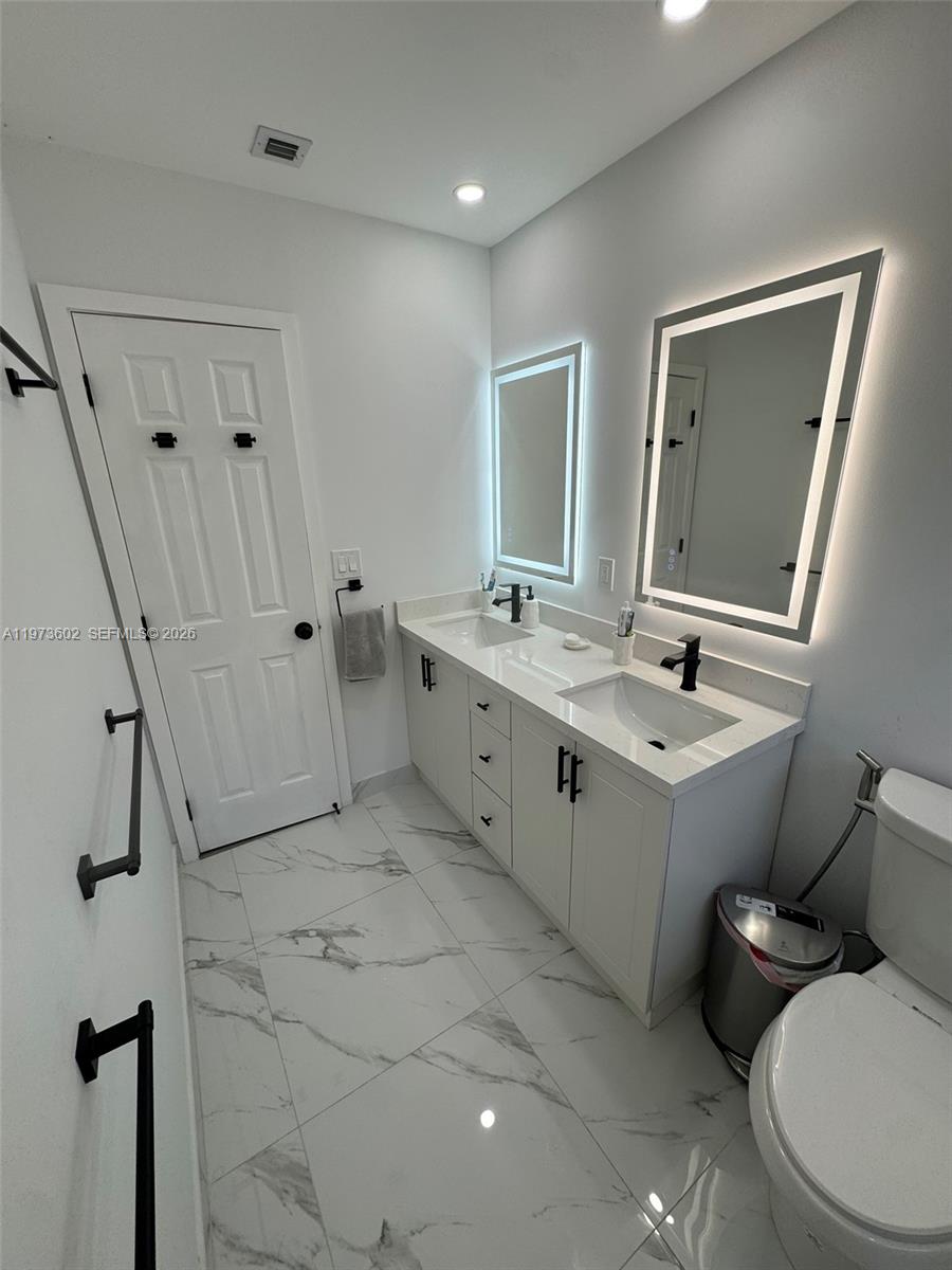 12534 Southwest 27th Street Miami, FL 33175 - Photo 30 of 49 a bathroom with a toilet sink and mirror