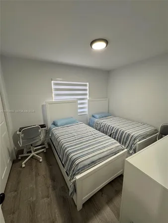 a bedroom with two beds and a desk
