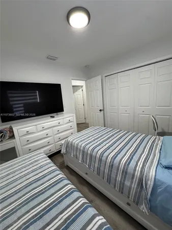 a bedroom with two beds and a flat screen tv