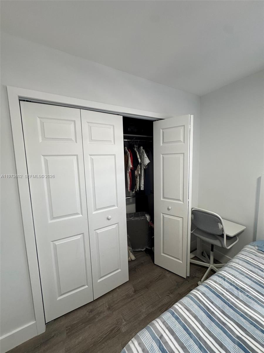 12534 Southwest 27th Street Miami, FL 33175 - Photo 35 of 49 a view of a closet area with bedroom and wooden floor