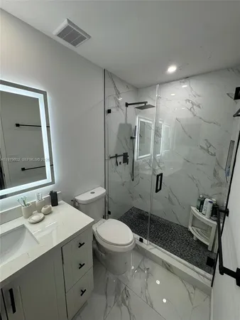 a bathroom with a sink toilet vanity and shower