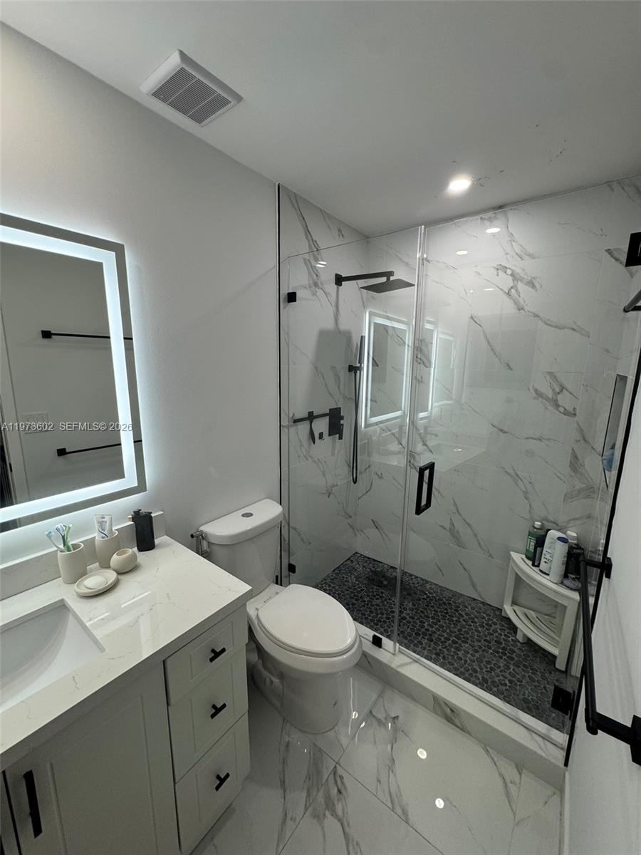 12534 Southwest 27th Street Miami, FL 33175 - Photo 36 of 49 a bathroom with a sink toilet vanity and shower