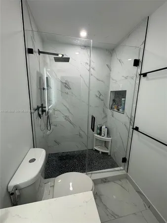 a bathroom with a sink a toilet and shower