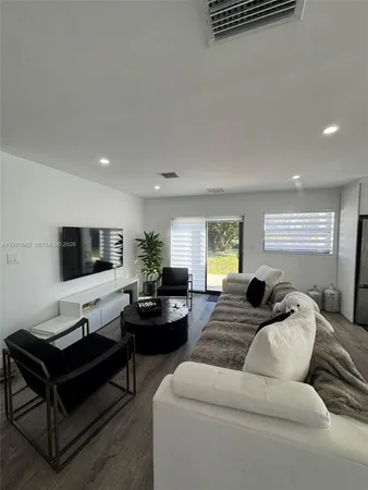 a living room with furniture window and a flat screen tv
