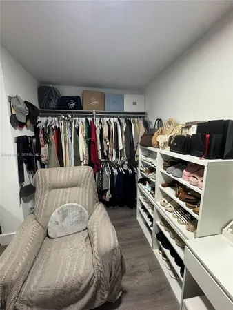 a view of walk in closet with clothes and shoes