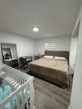 a bedroom with two beds and wooden floor