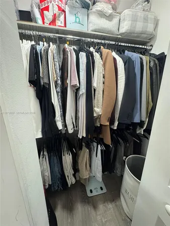 a view of walk in closet with clothes and shoes