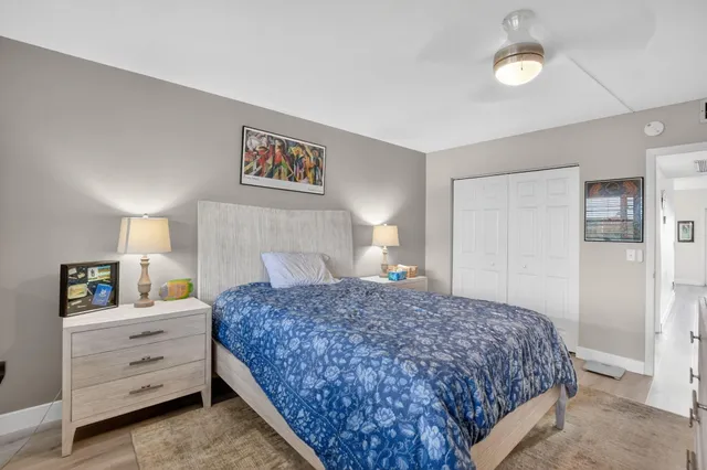 a bedroom with a bed and a lamp on dresser