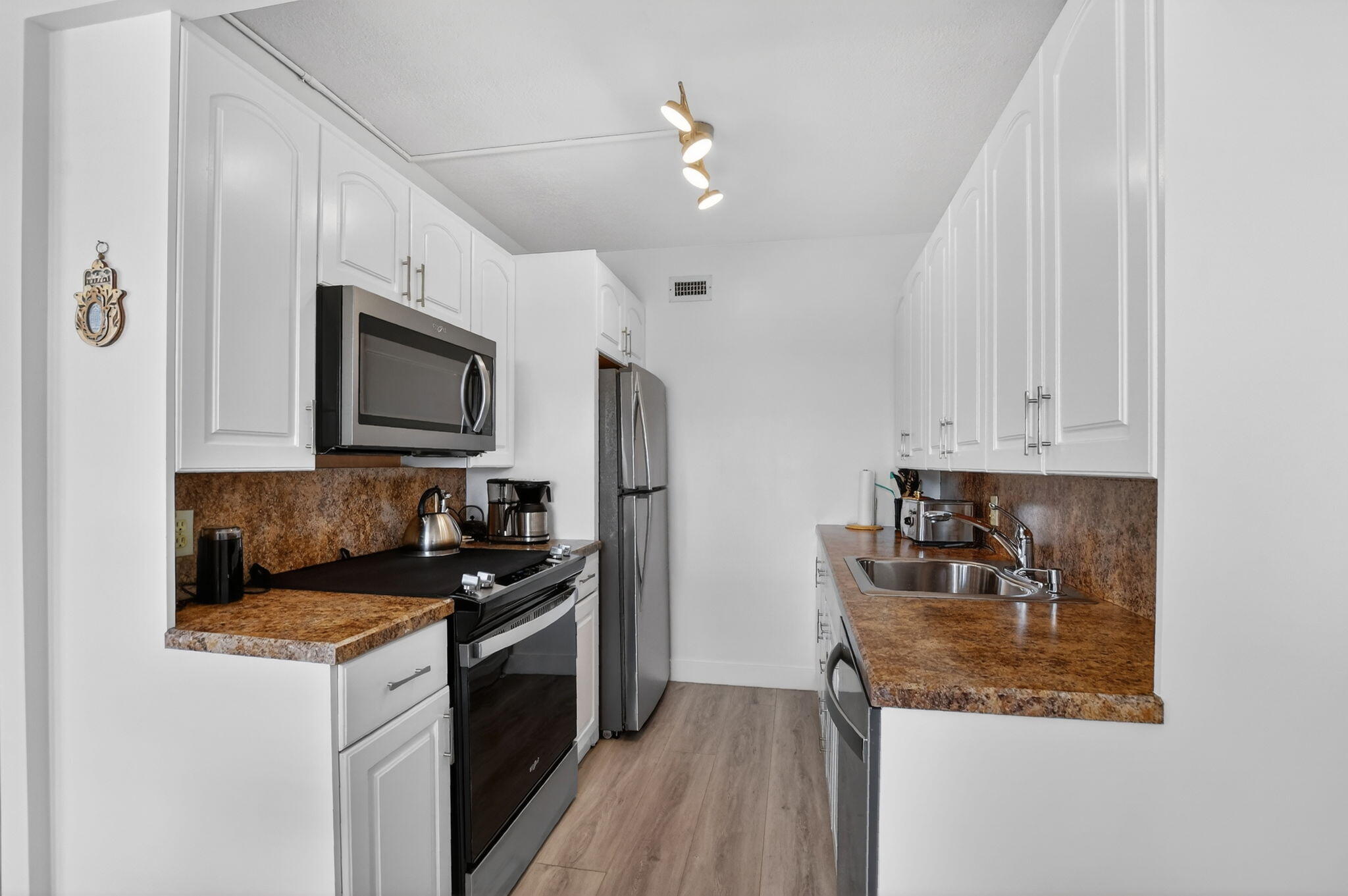 4051 Guilford C Boca Raton, FL 33434 - Photo 3 of 44 a kitchen with granite countertop a sink a stove top oven and cabinetry